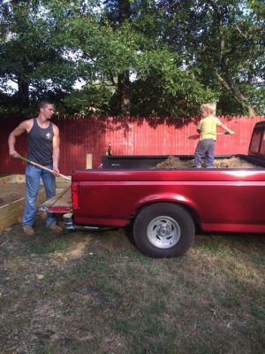 Brother Flowers working on the farm with his grandfather's red Ford pickup truck
